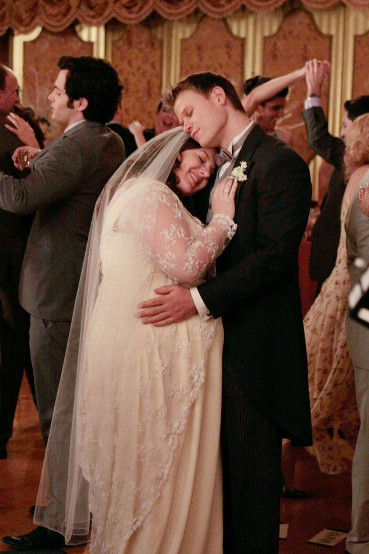 a bride and groom hugging in front of their guests