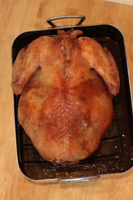 a cooked chicken sitting on top of a metal pan