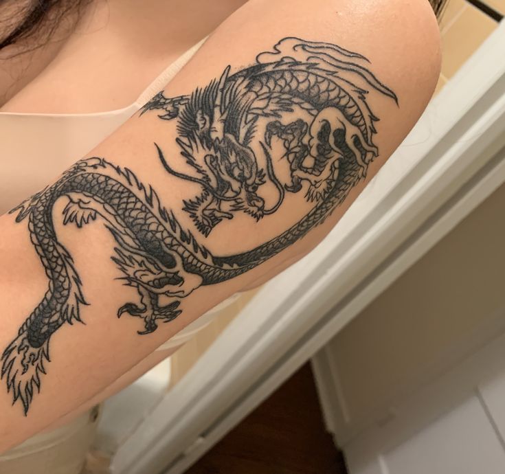 a woman with a dragon tattoo on her arm