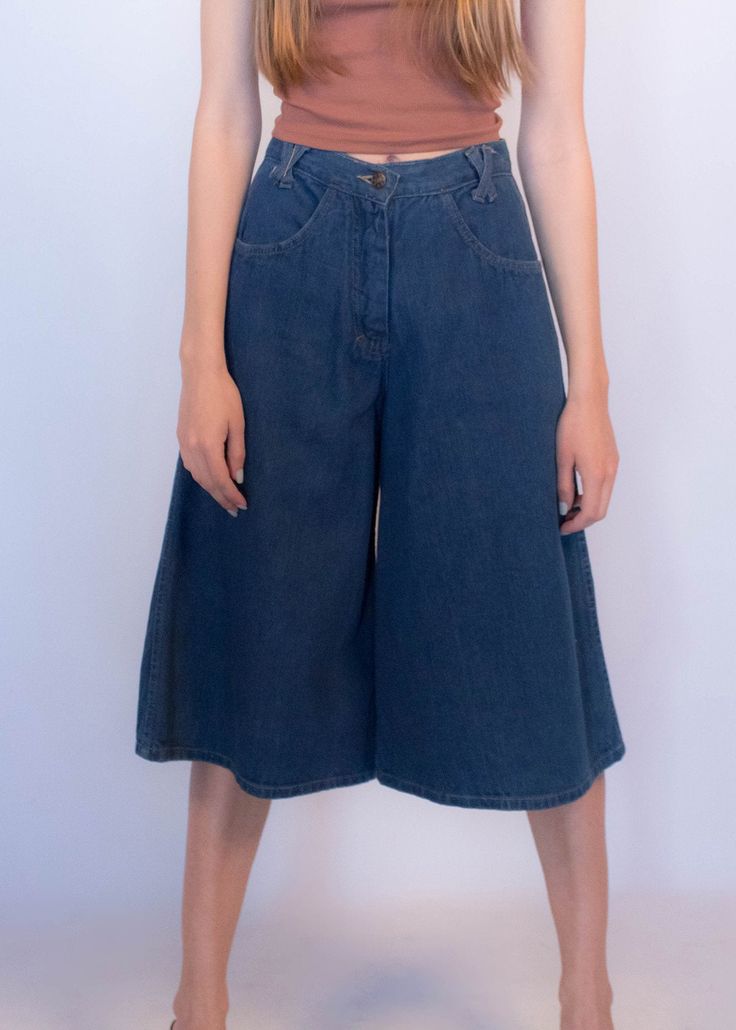 "Vintage 70s boho denim culottes. These great culottes are trending this season and are just perfect for summer style! High-waist fit. X criss-cross belt loops. Front pockets. Back western yoke detail. Wide-leg silhouette. Front button and zipper fastening. Unlined. Cut from 100% cotton. We kindly ask that you please view all measurements for comparison so you can get your desired fit. * Brand: n/a * Decade: 1970s * Fabric: 100% Cotton * Lining: Unlined * Color: Medium Dark Wash C O N D I T I O Retro High Waist Flare Jeans For Spring, Retro Wide Leg Bottoms For Spring, Spring Wide Leg Flare Jeans With Belt Loops, Spring Wide-leg Flare Jeans With Belt Loops, Summer Wide Leg Pants With Belt Loops, Wide Leg Cropped Jeans With Belt Loops For Spring, High Waist Flare Jeans With Belt Loops For Spring, Retro Wide Leg Jeans For Summer, Spring Cropped Leg Flare Jeans