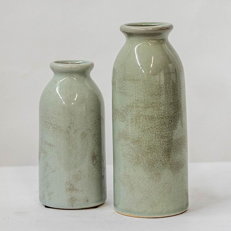 two green vases sitting next to each other