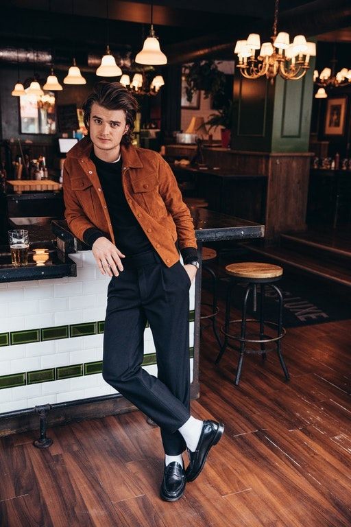 a man sitting on top of a counter next to a wooden floor in a restaurant