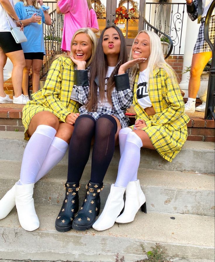 three women sitting on the steps in front of some stairs and one is wearing white socks