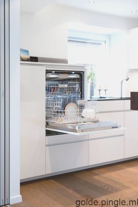 an open dishwasher in the middle of a kitchen with white cabinets and wood floors