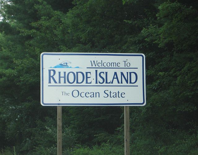 a welcome sign for rhode island, the ocean state in front of some green trees