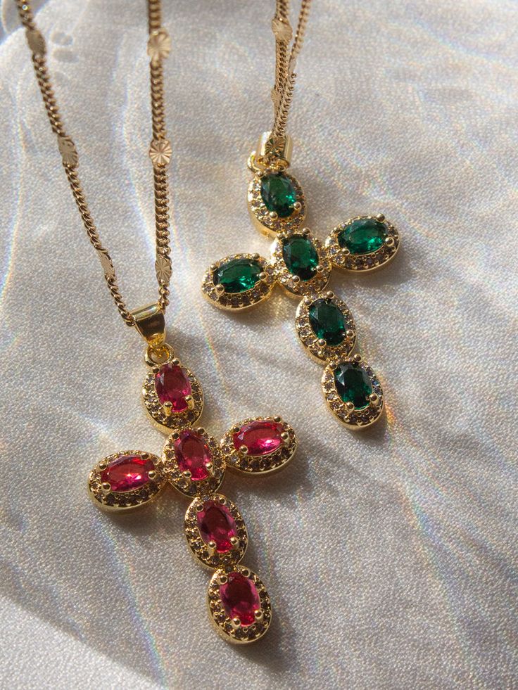 The Aurora Cross Necklace will be your new favorite to reach for. This stunning piece features an eye catching, bright fuchsia gemstone cross pendant that is outlined by sparkling clear CZ stones that hangs off a gleaming starburst chain. Gold filled Charm : 41.5mm x 23.8mm x 4.7mm Chain : 17.5" ﻿﻿by The Obcessory Crystal Cross Necklace, Emerald Cross, Hand Jewelry Rings, Dope Jewelry Accessories, Earthy Jewelry, Emerald Gem, Gold Cross Necklace, Jewelry Accessories Ideas, Dope Jewelry