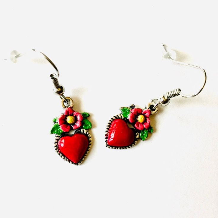 Embrace the adventurous spirit of Frida Kahlo with these intricately hand-painted heart earrings. Every pair is carefully crafted in our studio, paying close attention to even the smallest details and finished with a striking coat of enamel. These tiny-yet-gorgeous earrings are a one-of-a-kind and budget-friendly present, ideal for yourself or someone special. Don't hesitate to claim these captivating Frida-inspired earrings for yourself! These heart-shaped dangling earrings are not only a uniqu Handmade Heart-shaped Enamel Earrings, Heart-shaped Enamel Earrings With Charm, Heart Charm Enamel Earrings, Enamel Heart Charm Earrings As Gift, Enamel Earrings With Heart Charm As Gift, Valentine's Day Heart Charm Enamel Earrings, Hand Painted Heart Earrings For Valentine's Day Gift, Handmade Enamel Jewelry For Valentine's Day, Hand-painted Red Jewelry For Valentine's Day