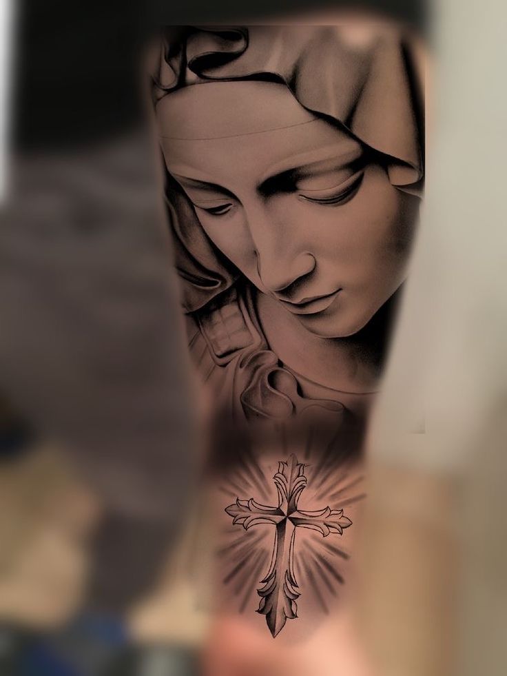 a person with a tattoo on their arm holding up a cross and the image of jesus