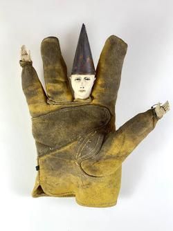 an old glove with a man's head and hands holding something in the shape of a hand