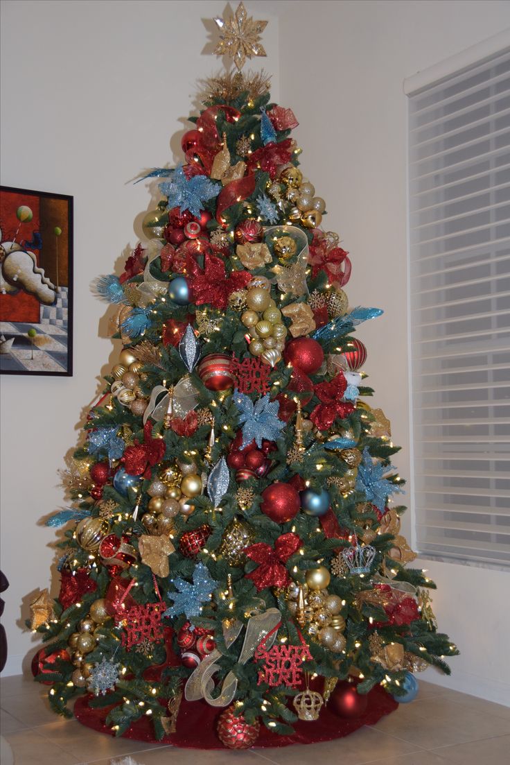 a christmas tree decorated with red, gold and blue ornaments