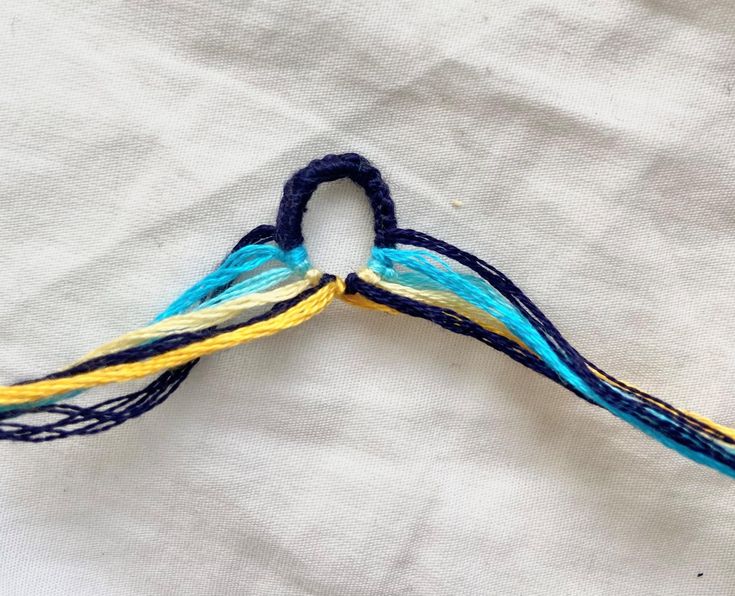 a pair of scissors are sitting on top of a piece of fabric that has been stitched together