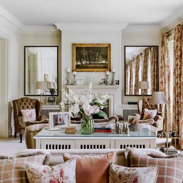 a living room filled with lots of furniture and flowers on top of a coffee table