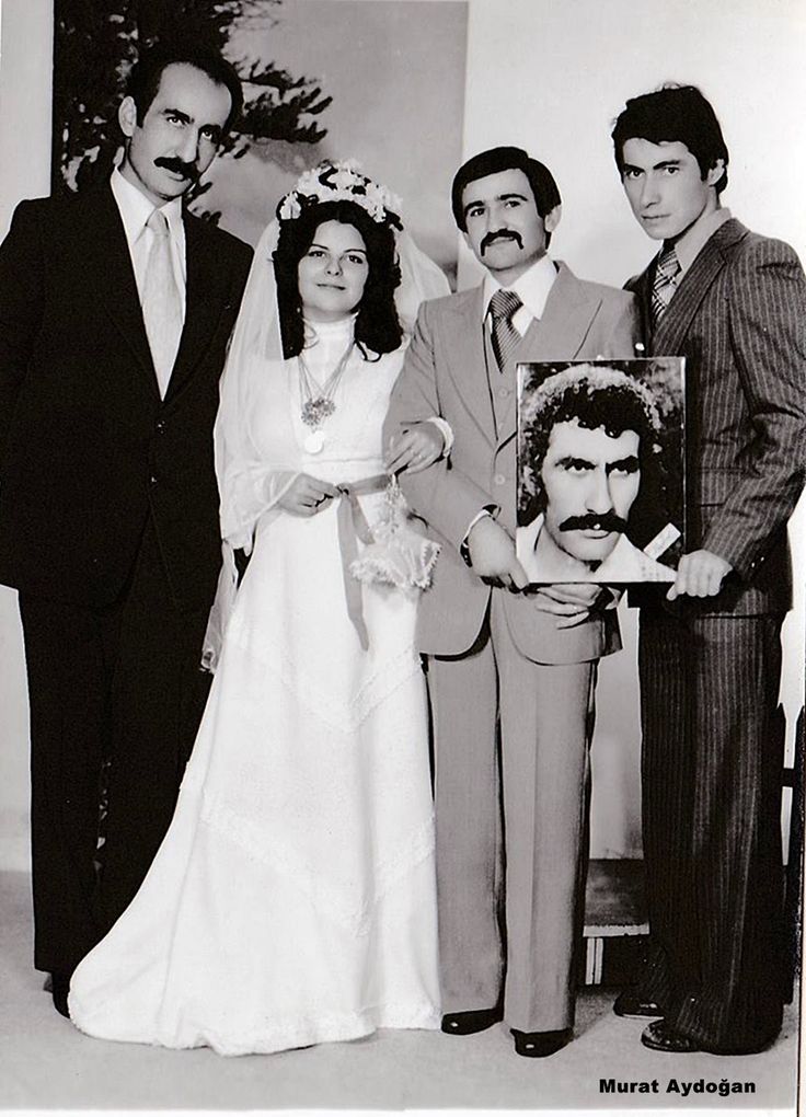 an old black and white photo of people dressed in wedding attire, standing next to each other