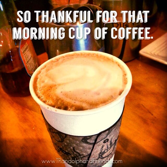 a cup of coffee sitting on top of a wooden table