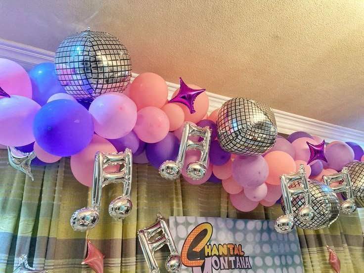 balloons and disco balls are hanging from the ceiling in front of a party sign that reads'50 '