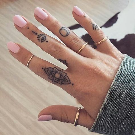 a woman's hand with two tattoos on her left and one on the right