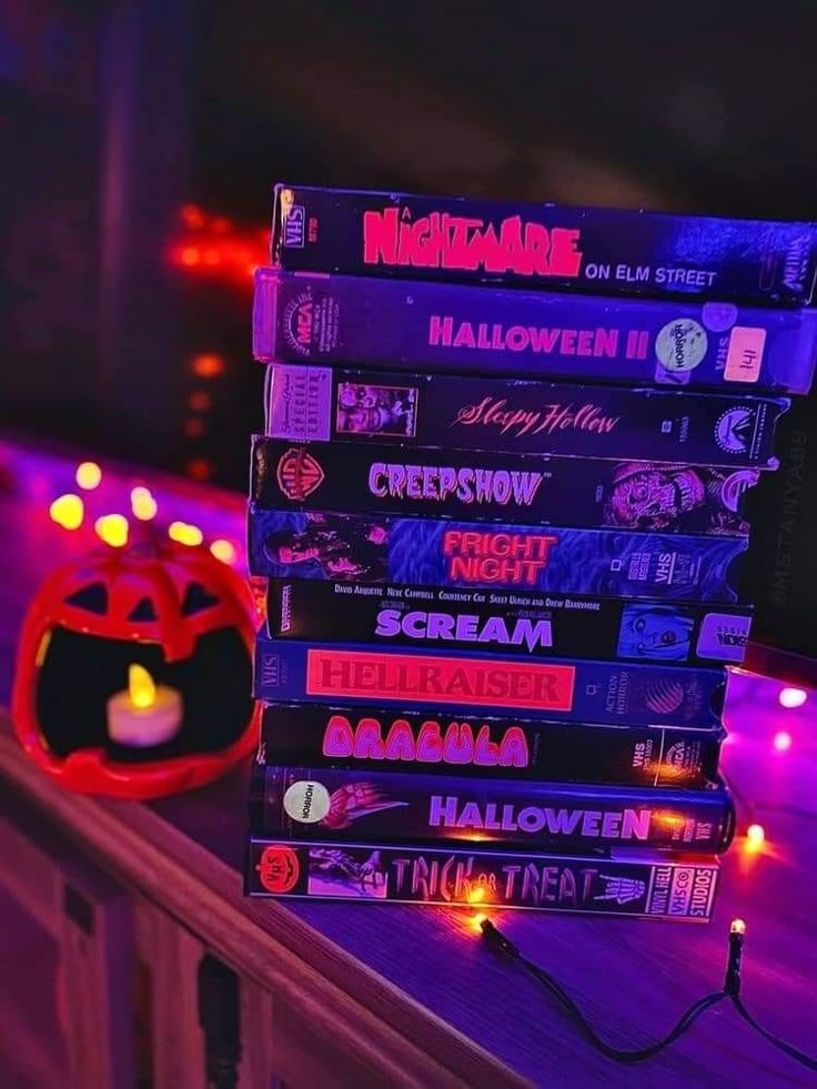 a stack of halloween movies sitting on top of a table