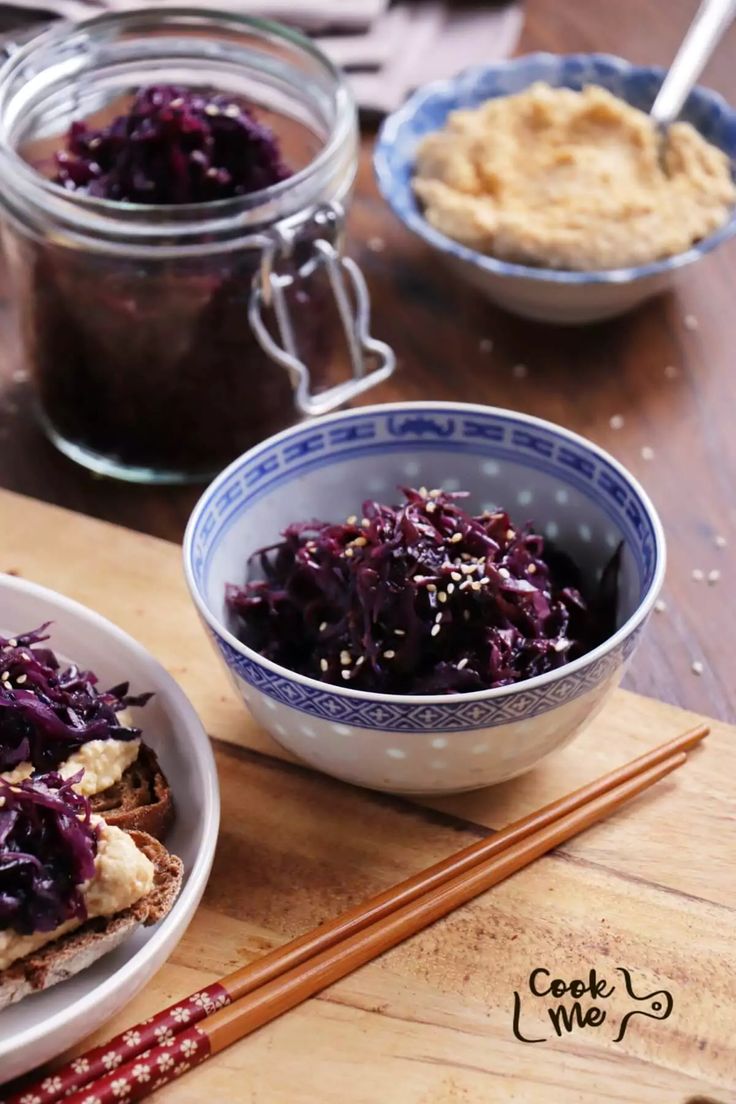 two bowls filled with food sitting on top of a wooden table next to chopsticks