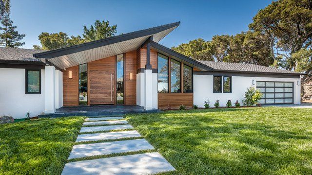 a modern house with grass and trees in the background