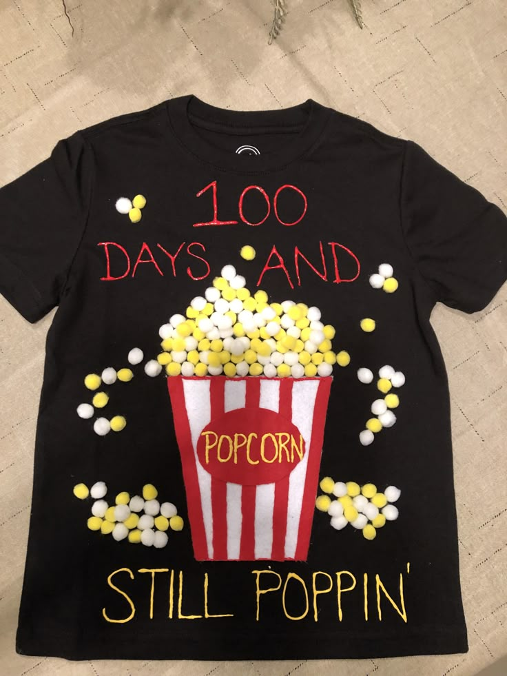 a t - shirt with popcorn on it that says 100 days and popcorn still popin '