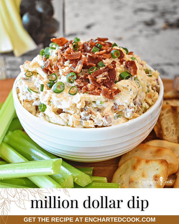 a white bowl filled with dip surrounded by crackers and celery