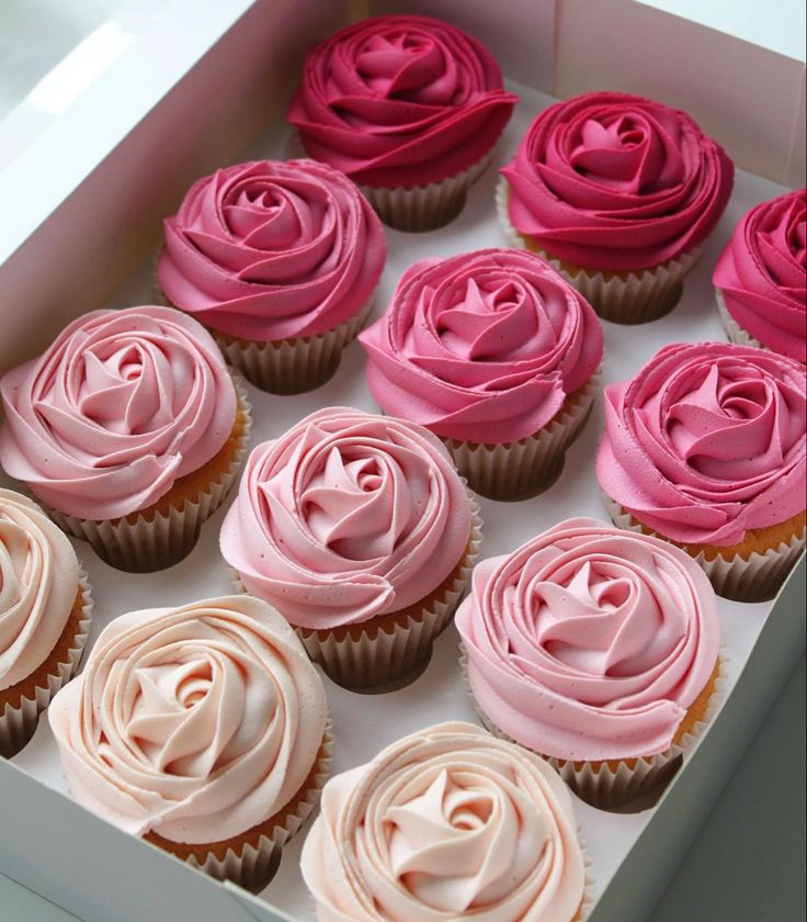 there are many cupcakes with pink frosting on the top and one has a rose