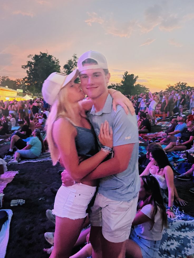 a man and woman hugging each other in front of an audience at a music festival