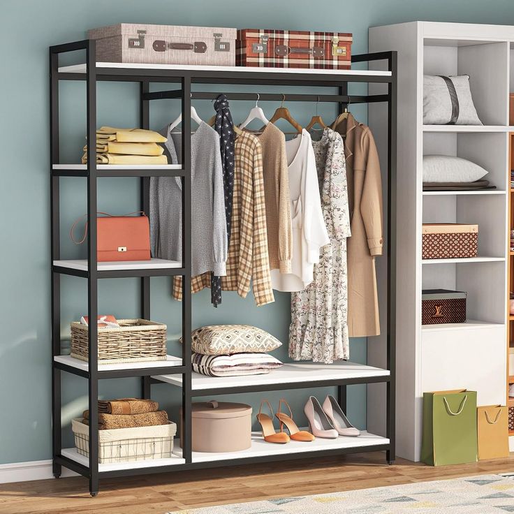 an organized closet with clothes, shoes and other items on shelving unit in blue walled room