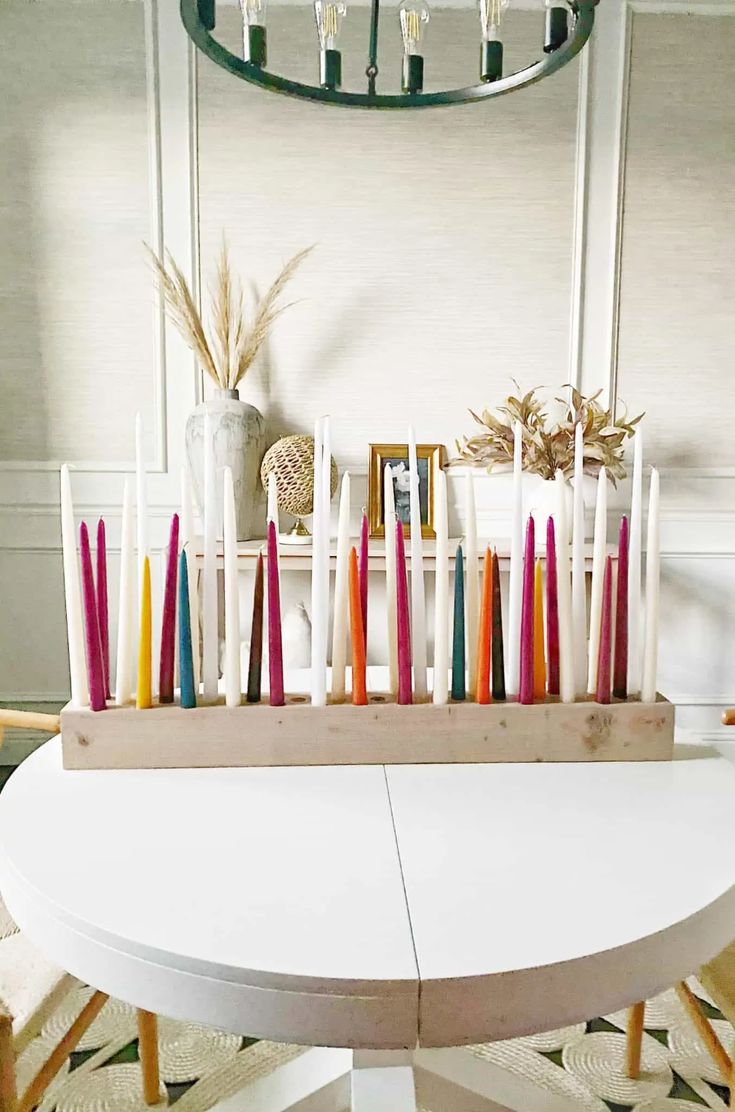 candles are lined up on a white table