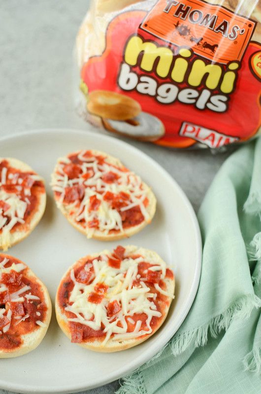 mini pizzas on a plate next to a bag of chips