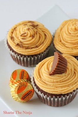 four cupcakes with peanut butter frosting on a white plate next to an easter egg