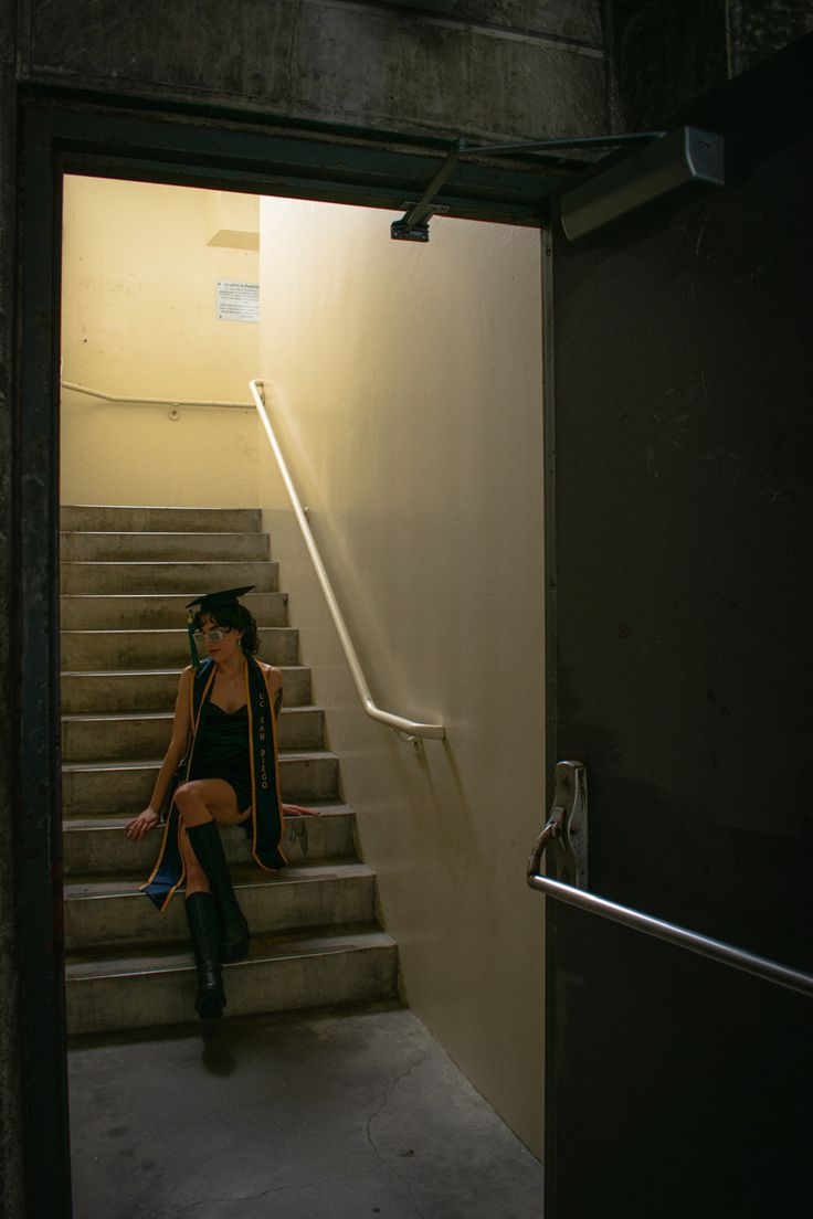 a woman sitting on the stairs in an empty building