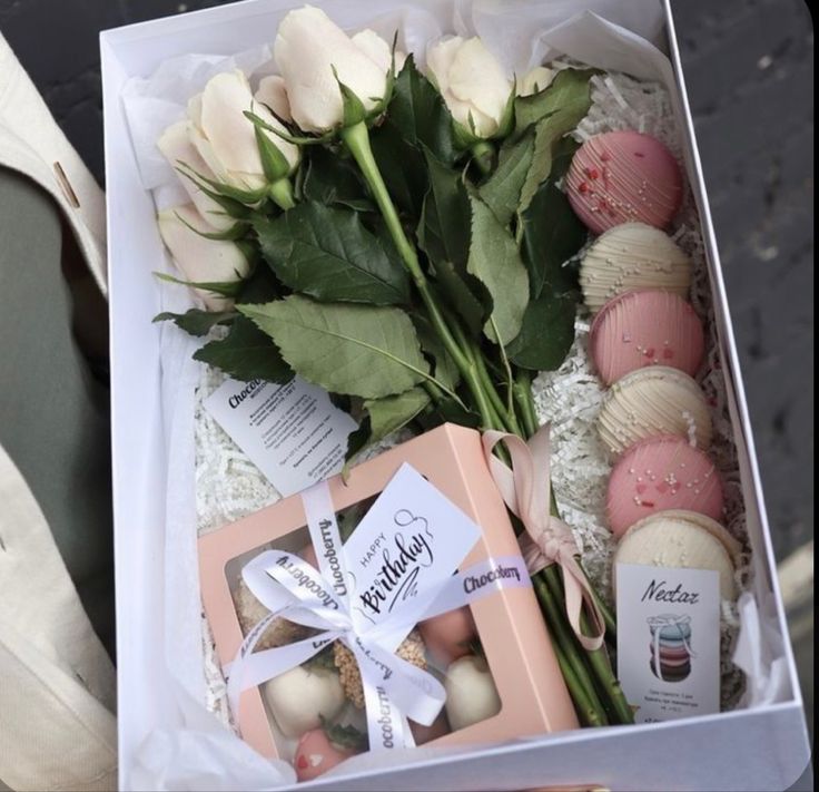 a box with roses, macaroons and soaps in it