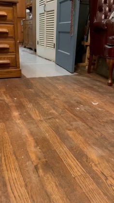 a wooden floor in a living room next to a dresser