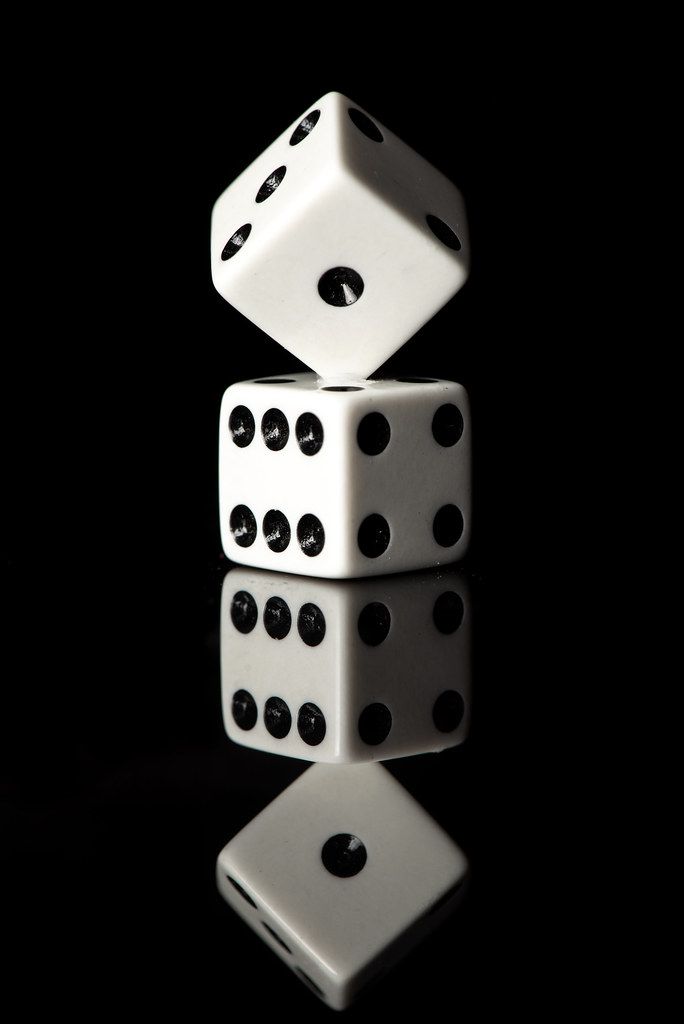 two dices stacked on top of each other in the middle of a black background