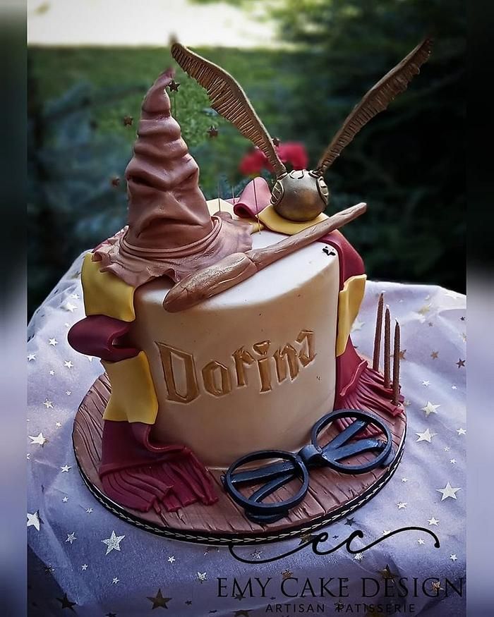 a harry potter themed birthday cake with glasses and wands on it's top