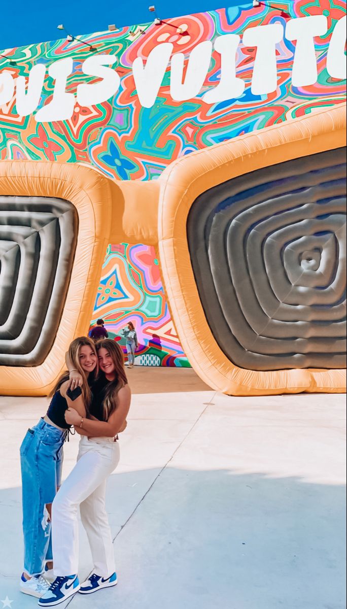 two women standing in front of an inflatable object