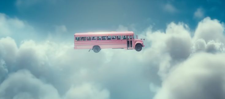 a pink bus is flying through the clouds