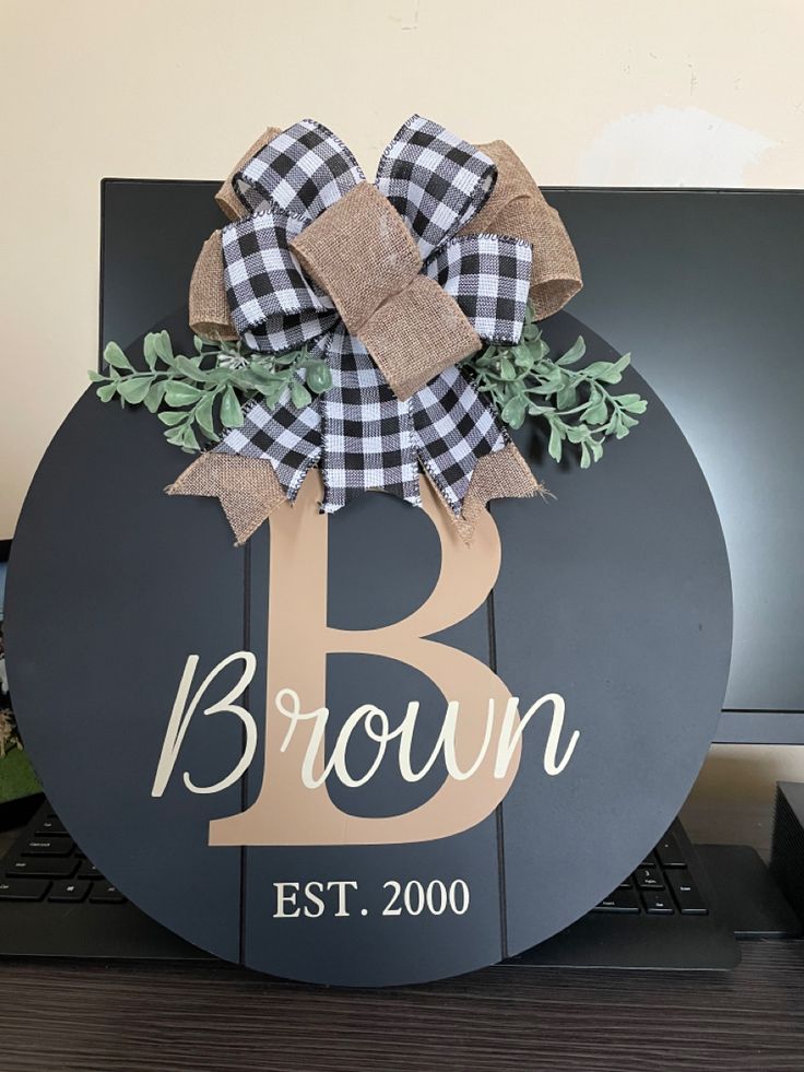 a black and white sign with a bow on it that says brown est 2000