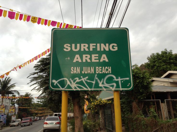 a green street sign sitting on the side of a road