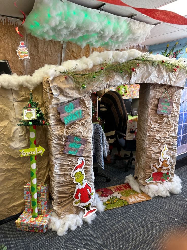 an office cubicle decorated with christmas decorations and paper mache on the walls,