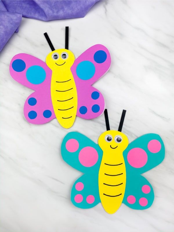 two paper butterflies sitting on top of a table