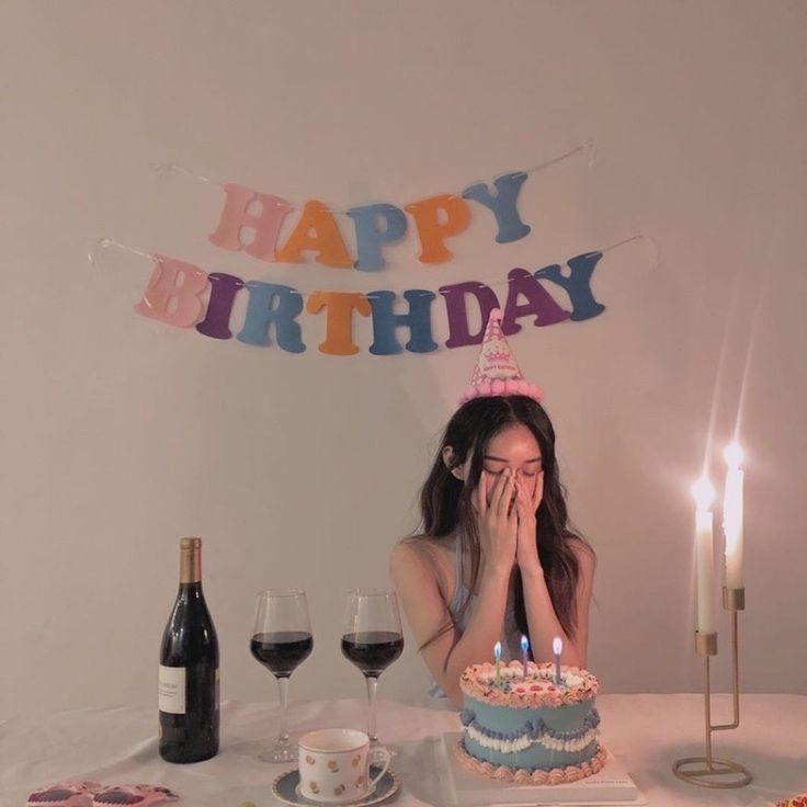 a woman sitting at a table in front of a birthday cake with candles on it