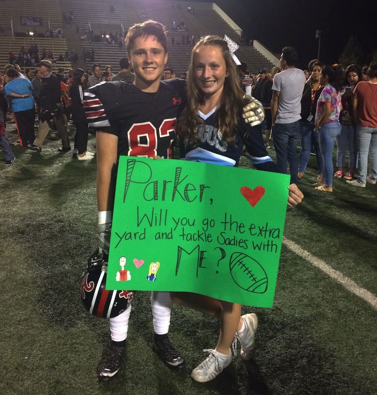 two people holding up a sign at a football game