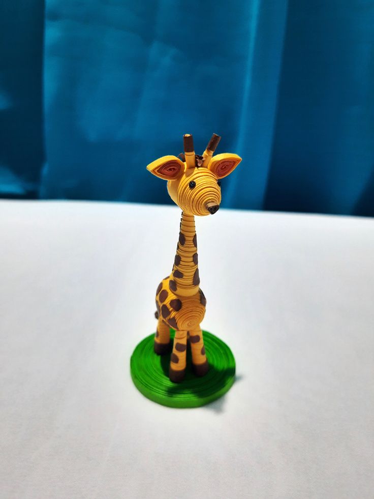 a toy giraffe standing on top of a green plate