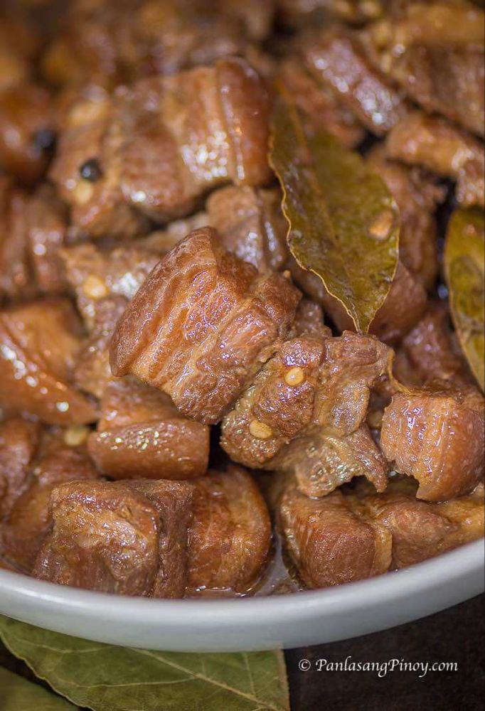 a bowl filled with meat and leaves on top of a table