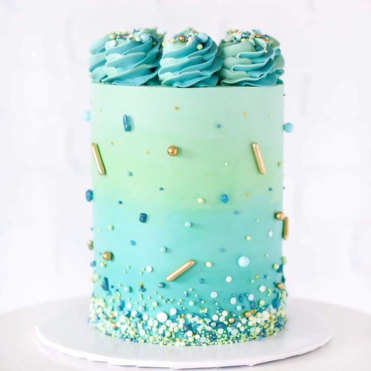 a blue and green cake with gold sprinkles