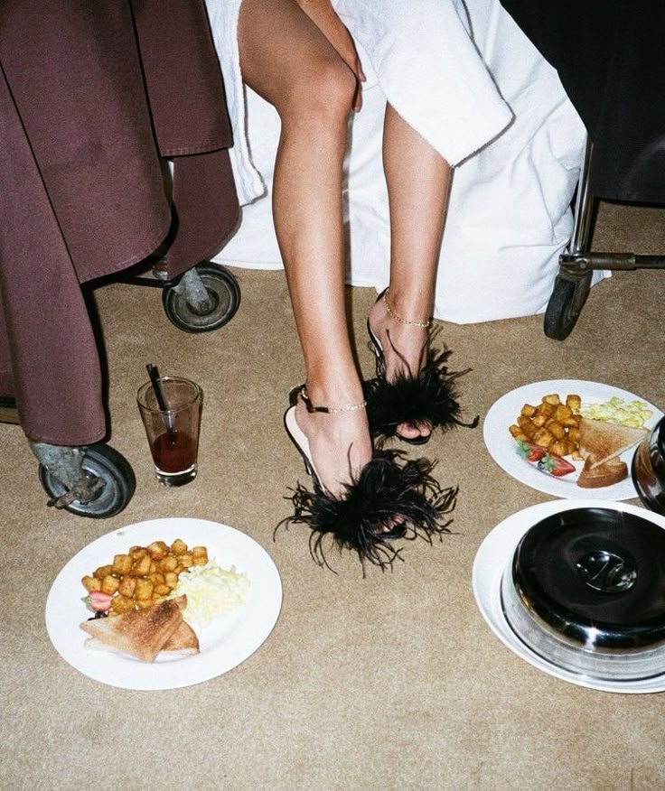 a woman's feet in black feathers on plates