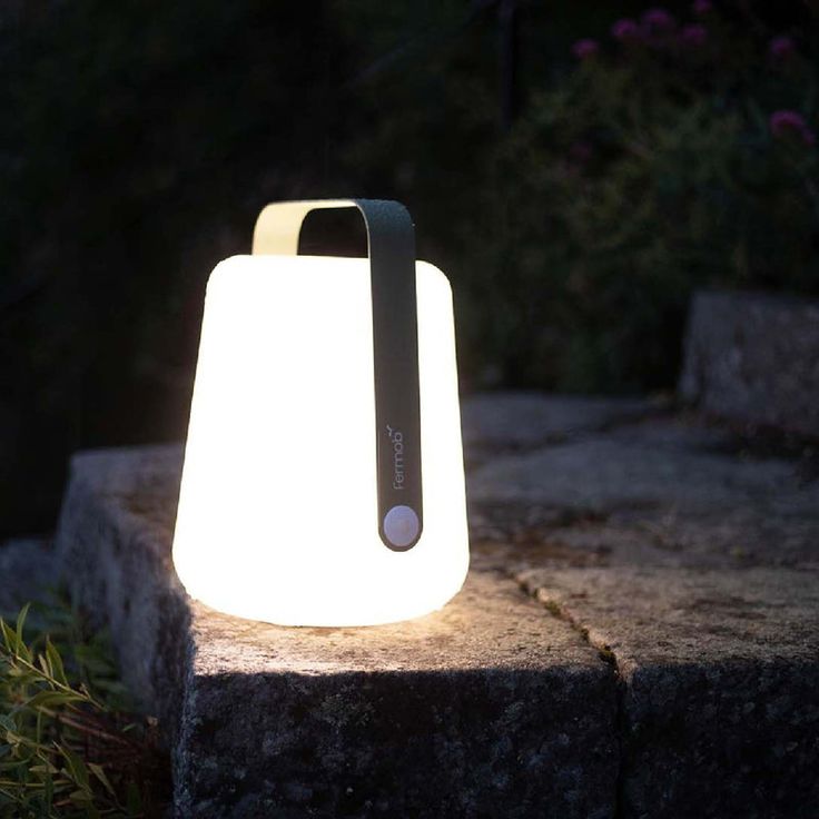 a small light sitting on top of a stone block in the grass at night time