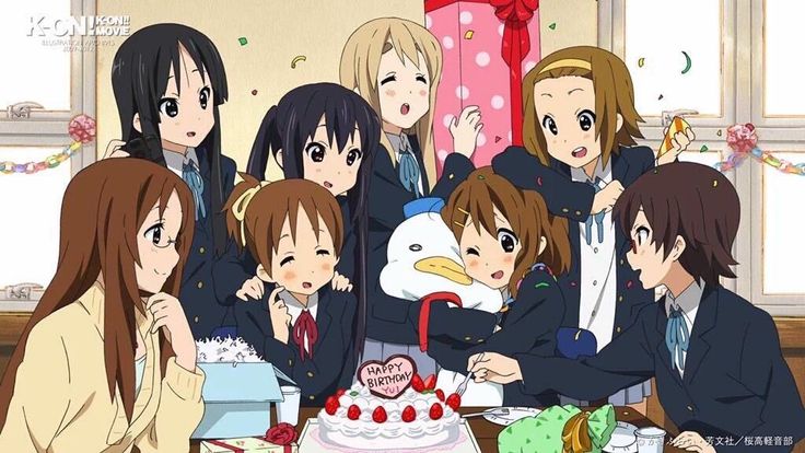 a group of people sitting around a table with a cake in front of them on it